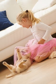 Child, playing and a dog together in a house for love, care and development. Happy girl kid and animal puppy or pet in on living room floor to play tickle game as friends for happiness and trust.