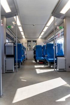 a commuter train car. A fun trip. Get around by public transport. Holidays, a trip to school. traveling by train. Interior of railway transport. a train car with seats and windows. vertical photo