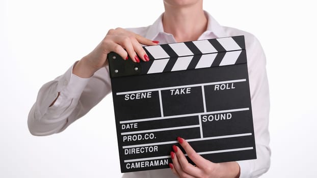 Woman assistant director banging clapper while filming closeup. Film production and cinema concept