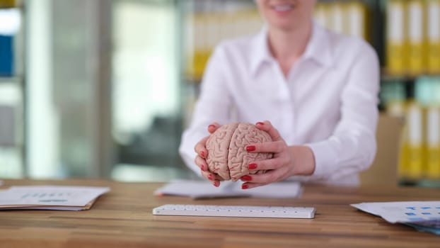 Female hands putting human brain on keyboard closeup. Artificial intelligence concept