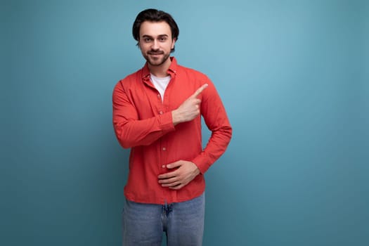 a handsome young brunette man in a red shirt tells interesting news.