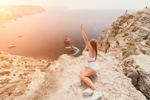 Woman travel sea. Happy tourist in hat enjoy taking picture outdoors for memories. Woman traveler posing on the beach at sea surrounded by volcanic mountains, sharing travel adventure journey