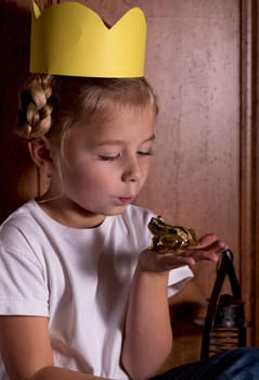 princess girl with toy frog. Cute little girl playing with a toy frog, pretending to be a princess