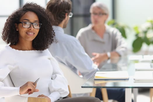 young attractive african american woman in the office sitting at the table