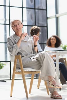 mature woman sitting with laptop looking at camera.