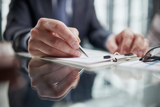 man hands with pen writing on notebook in the office.learning, education and work