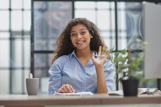 Smiling businesswoman or helpline operator with headset and computer at office