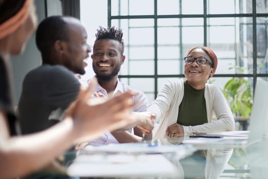 team of young african people in the office shaking hands