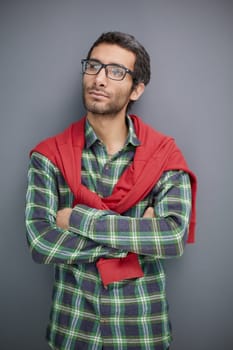Portrait of positive businessman in formal attire and glasses looking to the side on gray background.