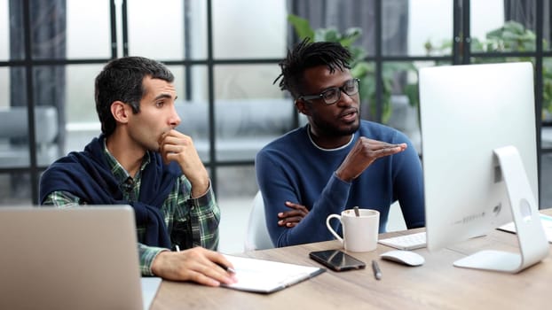 Business people working together in a modern trendy office behind a laptop. The concept of joint discussion of the project