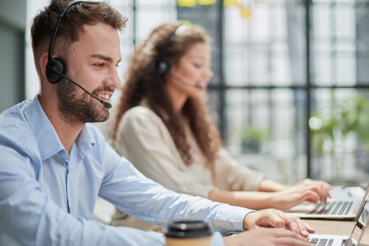 Handsome male customer service agent working in call center office as a telemarketer.
