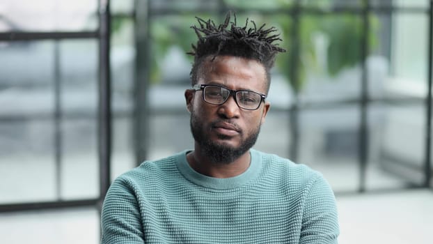 Portrait of a serious african american man, shaking his finger, warning and preventing you from something bad, looking at the camera with a worried expression.