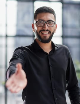 smiling businessman reaching out for a handshake