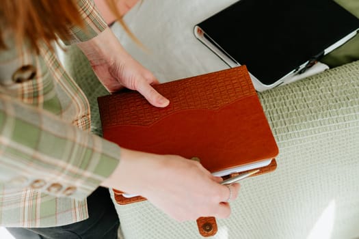 Business woman office secretary suit holding stack of notebooks. Student with a pile of notepads. Cropped girl in a stylish office outfit holds books in her hands. Blank mockup copy space notepads.