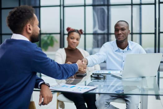 smiling diverse multiracial male business partners handshake close deal make agreement after successful negotiation