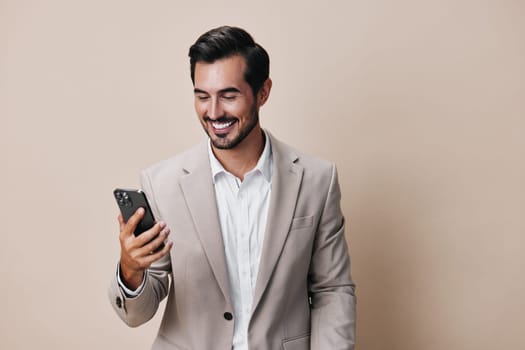 man message hold smile happy mobile phone internet young person call suit male business smartphone background online corporate lifestyle beige selfies portrait phone