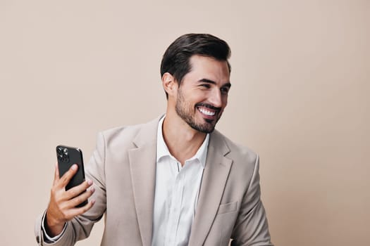 man technology hold confident suit handsome phone portrait copy business young smile space call happy application smartphone background person beige communication success