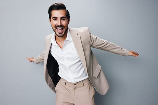 happy man fashion hand arm young stylish cheerful smile suit beige standing successful background winner business businessman idea victory posing male