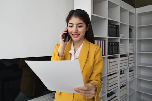 business woman talking on phone and working with documents at office.