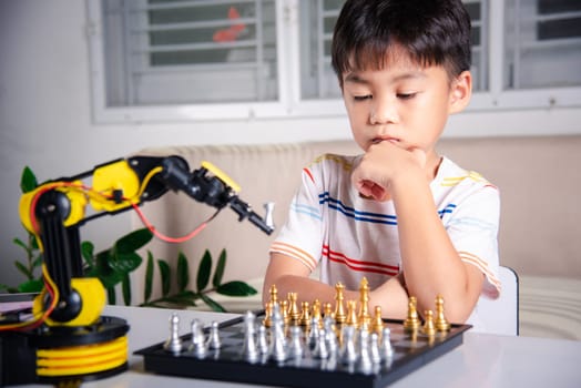 Asian little boy thinking and wait robot arm playing chess, STEM education E-learning, Funny children learning successful getting a lesson control robot arm game, Technology science education concept