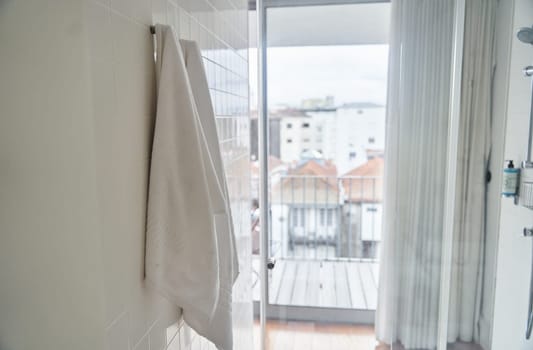 Two white towels hanging in the hotel shower room. High quality photo