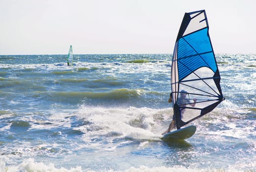 Young man surfing the wind on a bright summer day