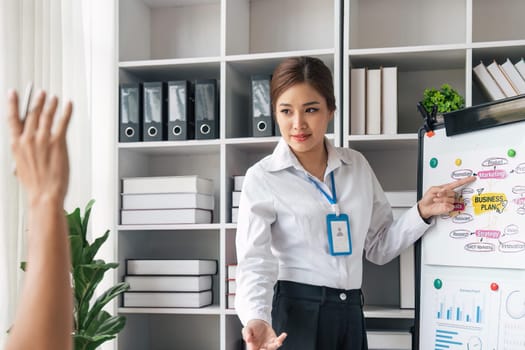 business woman listens to business man that raises a hand with the good comment at a business group meeting, New business plan in the office.