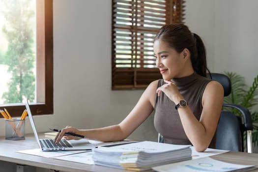 Asian woman working laptop. Business woman busy working on laptop computer at home.