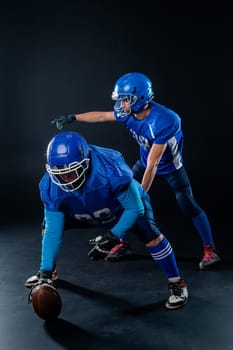 Two American football players are ready to start the game on a black background