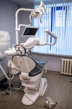 Dental interior office with modern equipment. Modern dental practice. Dental chair and other accessories used by dentists in blue, medic light