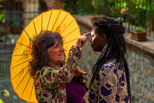 Diverse couple having fun in summertime in old village, outdoors. Funny expression. LGBT standout.