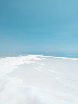 Landscape view on Dead Sea salt crystals formations, clear cyan green calm water at Ein Bokek beach, Israel