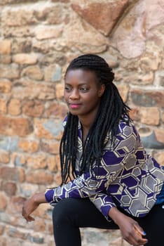 Happy young black woman smile. Stylish model. Braid dreadlock hairstyle. Joyful smiley African female in selective focus outdoors, fashion style, happiness concept. Outdoors.