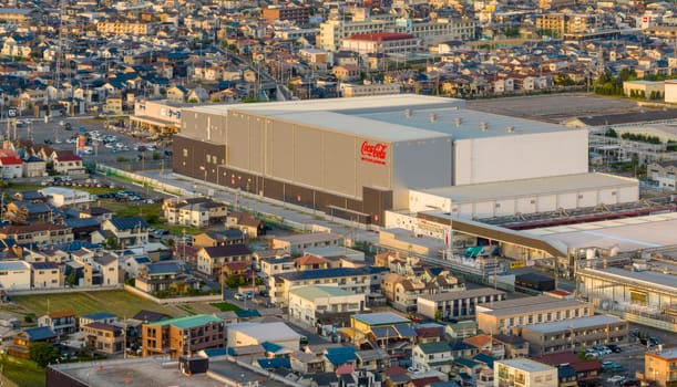 Okubo, Japan - May 20, 2023: Coca Cola bottling plant by houses in Japanese neighborhood. High quality photo