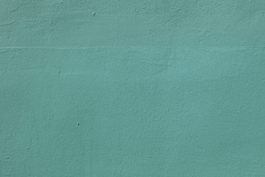 The surface of an old worn wall in blue and green. Background for a design with copy space.