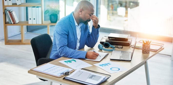 Burnout, laptop or corporate black man with headache in office with tax finance or company audit stress with lens flare. Sad, documents or employee with mental health, depression or financial anxiety.