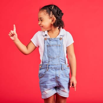 Mockup, black girl and finger for space, product placement and kid on studio background. African American female child, young person and brand development for advertising, happiness and cheerful.