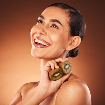 Beauty, skincare and woman in studio with kiwi fruit or natural face cleaning product for grooming routine. Mockup, wellness and happy girl model smiles with organic facial dermatology cosmetics.