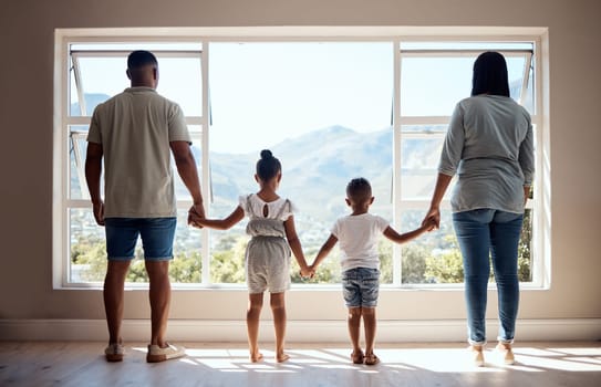 Love, back view and family holding hands by window looking at scenic view of nature, trees and mountain. Bonding, affection and mom and dad standing with kids in new apartment, happy in family home.