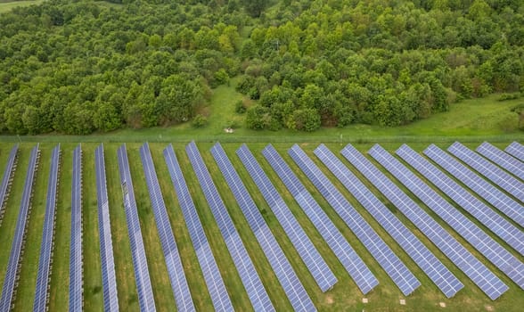 Renewable energy. Aerial shot drones fly over a photovoltaic power station. Group pf solar panels looking the sun for energy production.