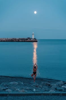 Full moon rises to the lighthouse, lunar path on the sea woman