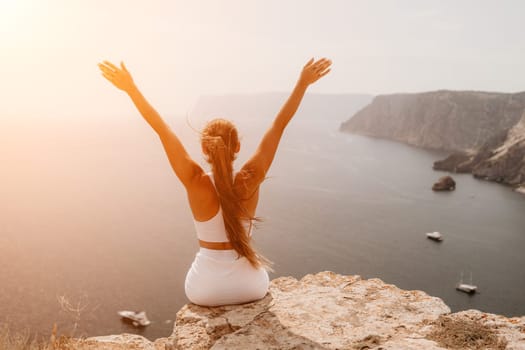 Middle aged well looking woman with black hair doing Pilates with the ring on the yoga mat near the sea on the pebble beach. Female fitness yoga concept. Healthy lifestyle, harmony and meditation.