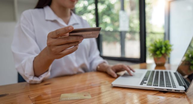 Hands holding credit card and using laptop. Online shopping.