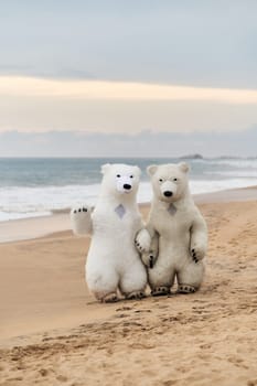 Animators dressed as polar bears entertain people on the beach. High quality photo
