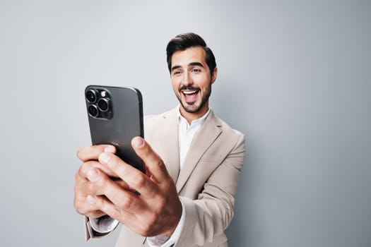 suit man success internet portrait smartphone connection studio business happy technology isolated phone confident hold lifestyle online entrepreneur handsome smile call