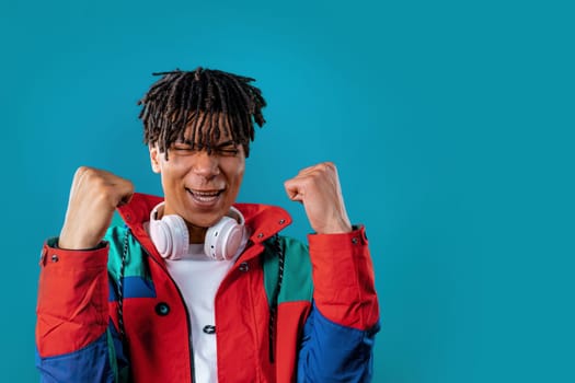 Friendly african man showing yes signal, approve. Positive smiling guy, body language. Correct perfect choice, great deal. Blue studio background.