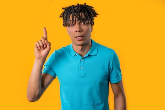 Smart young african man having idea eureka moment, pointing finger up on yellow background. Smart student guy showing answer gesture or remembered what he forgot, memory concept.