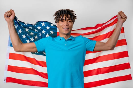 Happy african man with national USA flag on studio white background. American patriot, 4th of July - Independence day celebration, election, America, labor. US banner. High quality