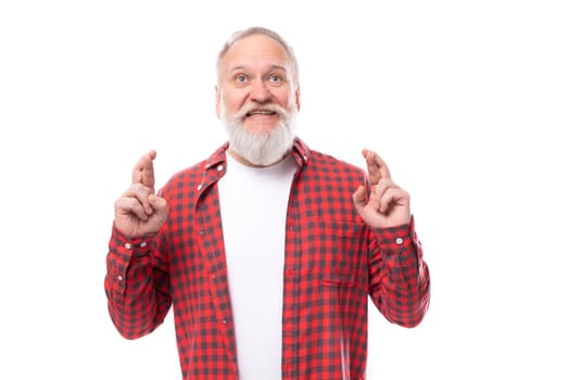 handsome 60s retired man with white beard and mustache crossed his fingers.