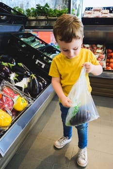 Little child choosing vegetables in a food store or supermarket. Healthy food. Healthy life. Healthy body. Healthy nutrition.